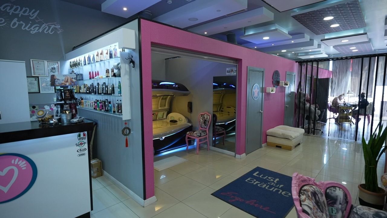 Sun Love salonu: pembe çerçeveli solaryum bölümü ve bakım ürünleri rafı